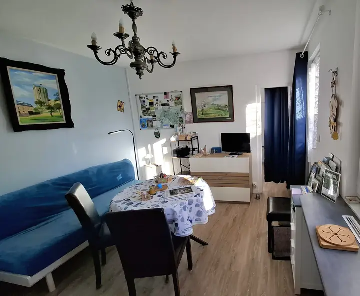Le coin repas près de la fenêtre, la télévision et le lit banquette