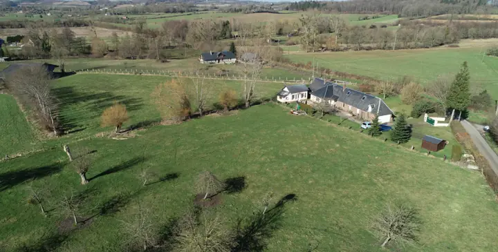 Vue du ciel : la petite maison et la maison des propriétaires au milieu des prés et des haies du Pays de Bray